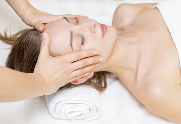 Femme allongé sur une table de massage pendant un soin reiki