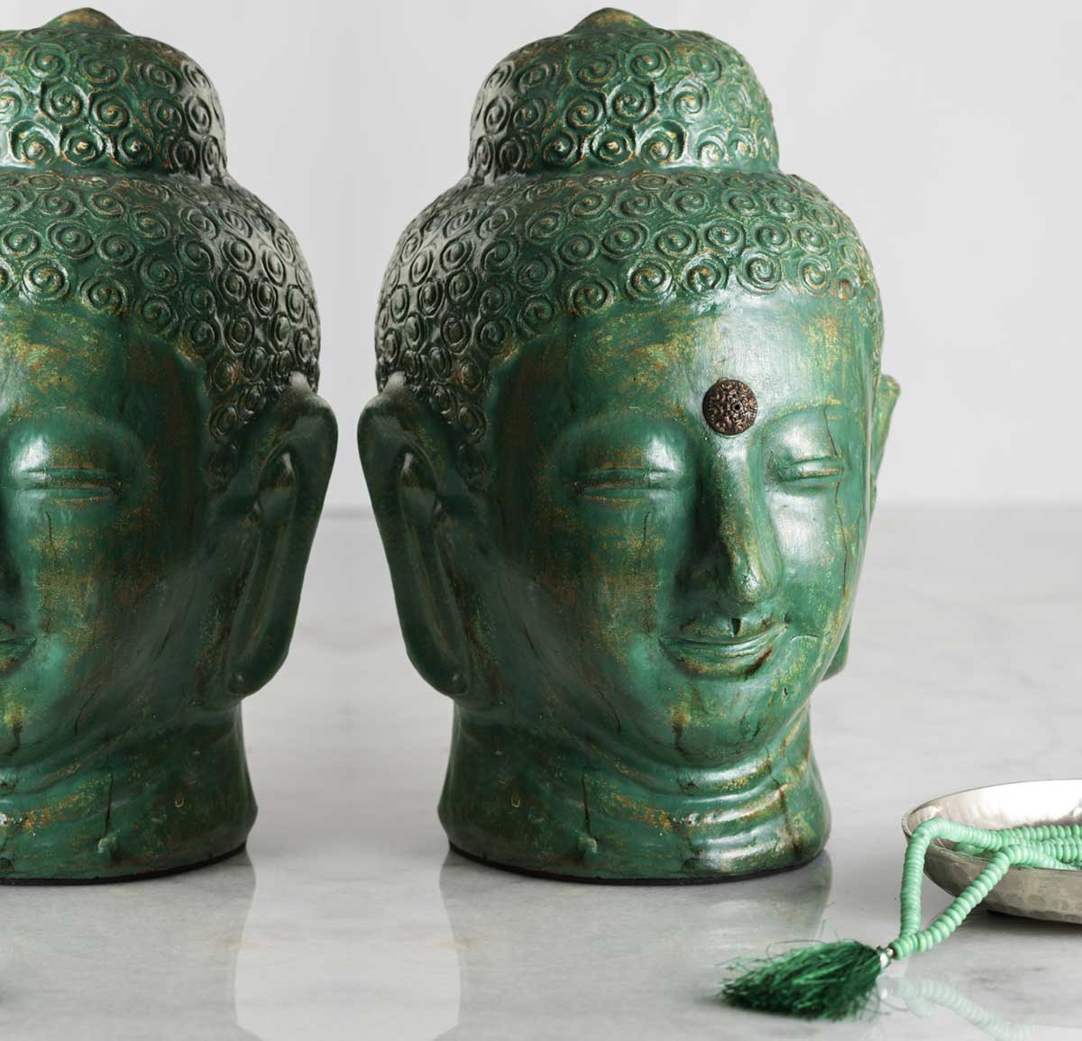 Visage d'un bouddha de couleur verte